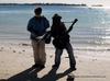 Jamaican men playing instruments on beach